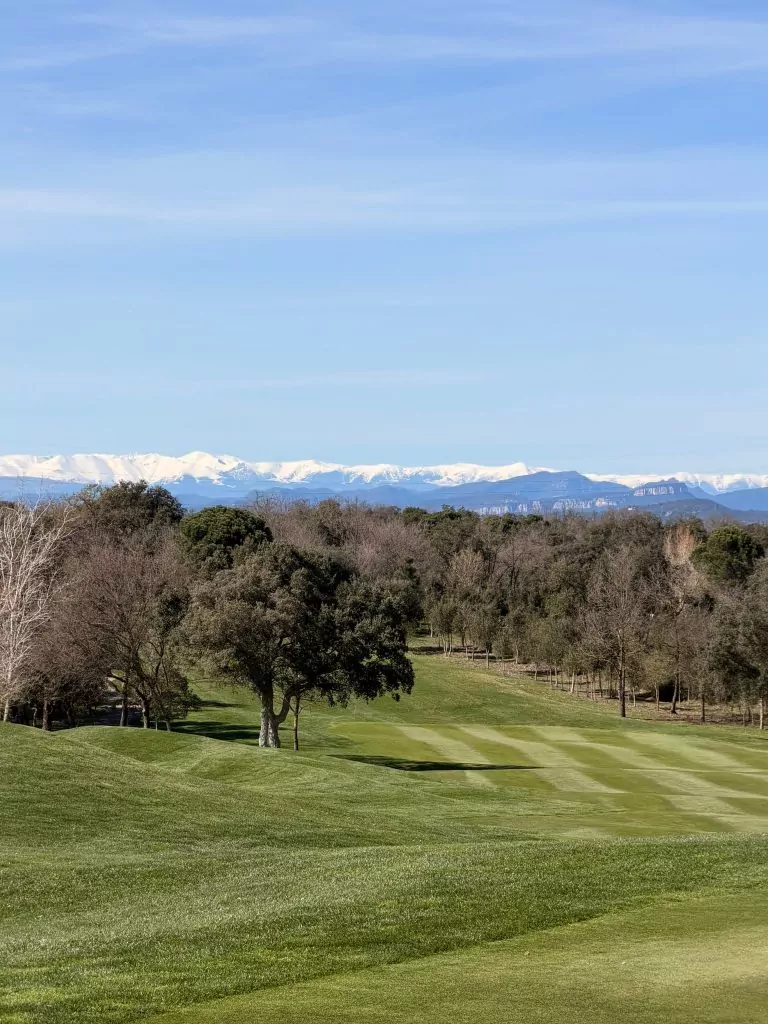 PGA Catalunya Tour Course mit verschneiten Pyrenäen im Hintergrund